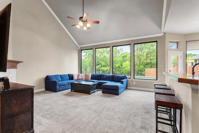 living area featuring vaulted ceiling, carpet floors, baseboards, healthy amount of natural light, and crown molding