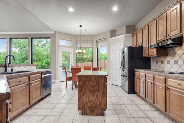 kitchen featuring under cabinet range hood, a sink, a kitchen island, black appliances, and backsplash