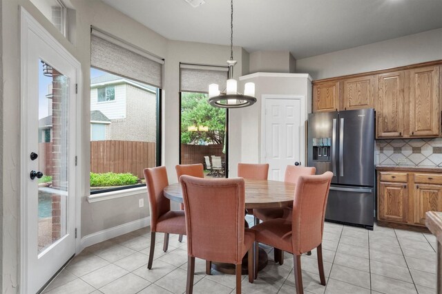 dining room featuring a chandelier, light tile patterned floors, and baseboards