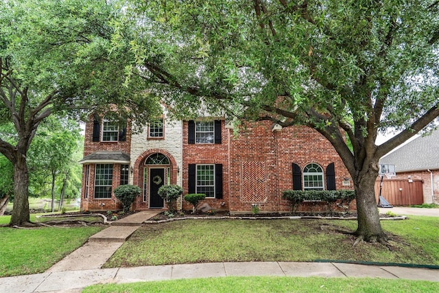 view of front of property with brick siding and a front lawn