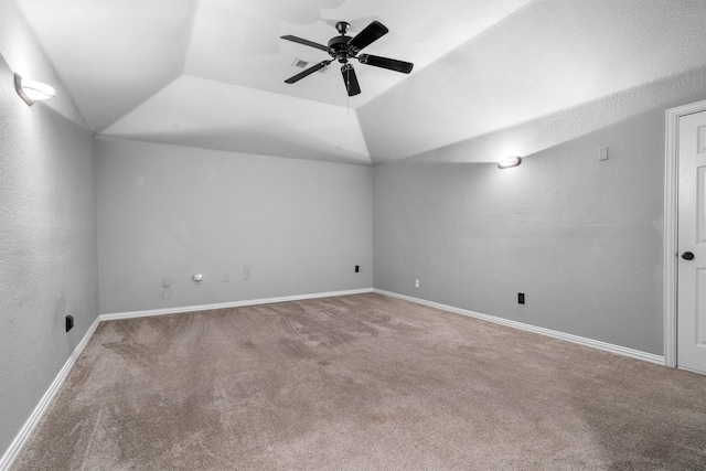 spare room featuring carpet, ceiling fan, lofted ceiling, and baseboards