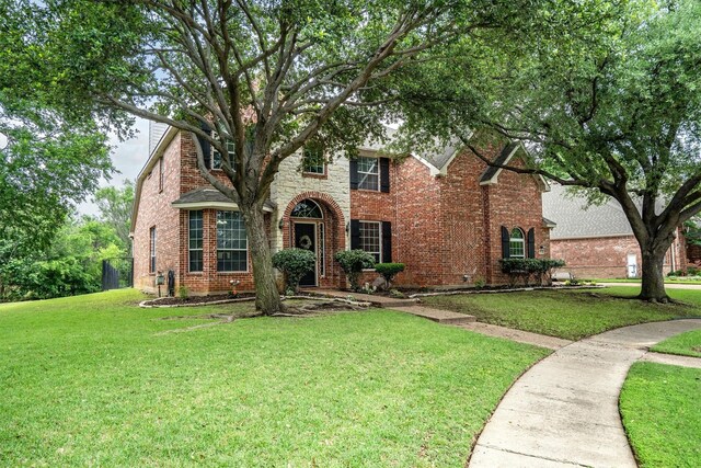 view of front of house with a front yard and brick siding