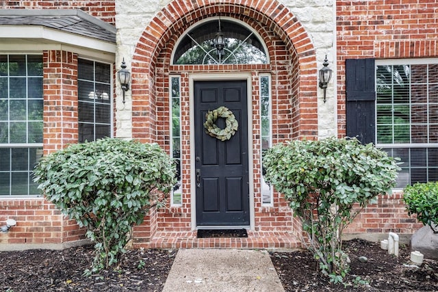 view of exterior entry with brick siding