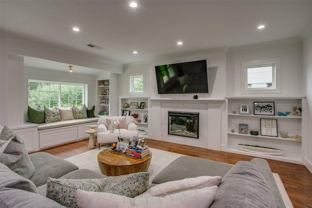 4719 Wateka Dr, Dallas, TX 75209 - living area with crown molding, wood finished floors, built in shelves, recessed lighting, and a premium fireplace
