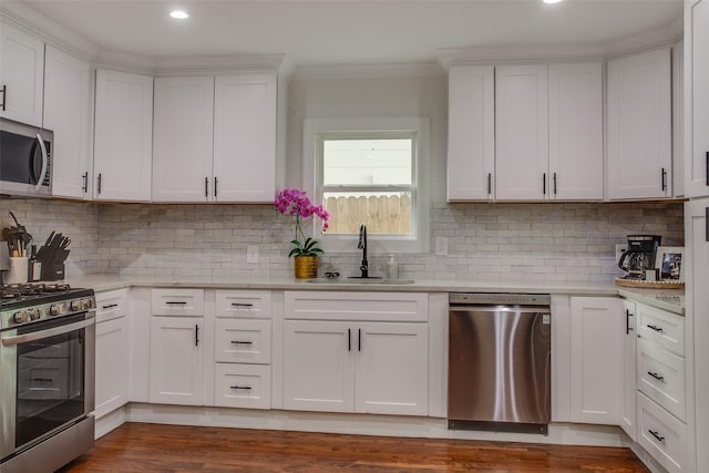 4719 Wateka Dr, Dallas, TX 75209 - kitchen with stainless steel appliances, a sink, light countertops, white cabinetry, and crown molding