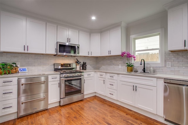 4719 Wateka Dr, Dallas, TX 75209 - kitchen with stainless steel appliances, a sink, light countertops, decorative backsplash, and crown molding
