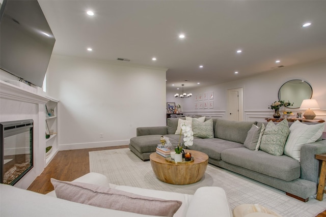 4719 Wateka Dr, Dallas, TX 75209 - living room with wood finished floors, recessed lighting, a fireplace, a chandelier, and ornamental molding