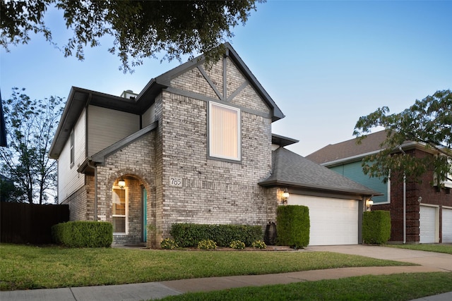 view of front of house featuring concrete driveway, a front lawn, a garage, and a shingled roof