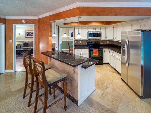 kitchen with stainless steel appliances, a peninsula, white cabinetry, a breakfast bar, and dark stone counters