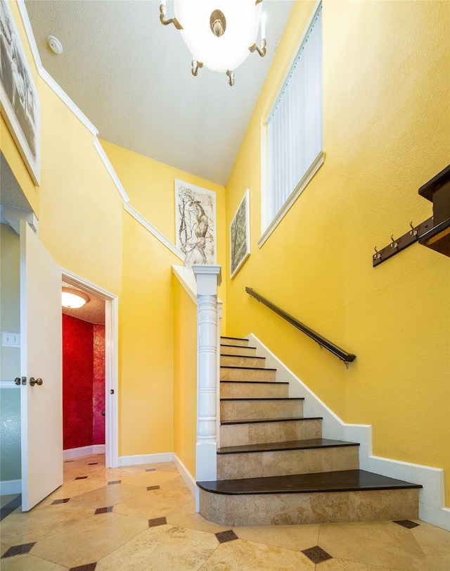 stairway featuring a high ceiling and tile patterned floors