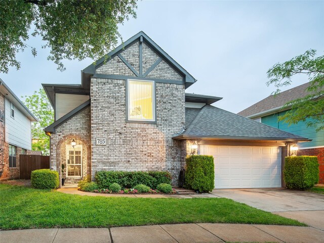view of front of home featuring an attached garage, driveway, brick siding, and a shingled roof