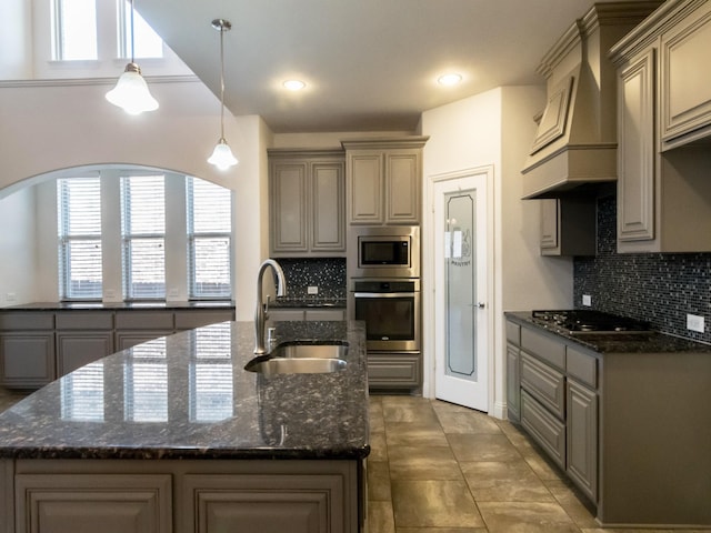 928 Freesia Dr, Little Elm, TX 75068 - kitchen with stainless steel appliances, a sink, gray cabinetry, backsplash, and custom range hood