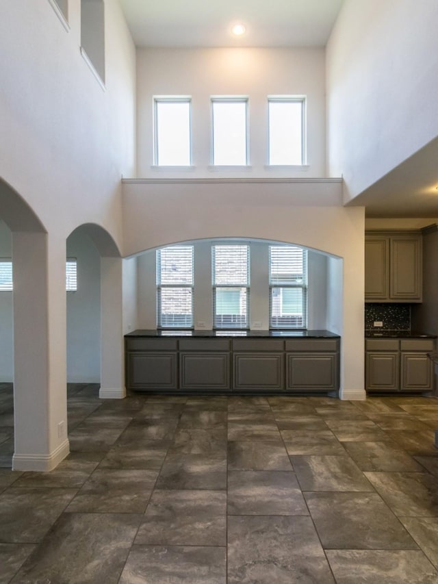 928 Freesia Dr, Little Elm, TX 75068 - unfurnished living room with a high ceiling, arched walkways, and baseboards