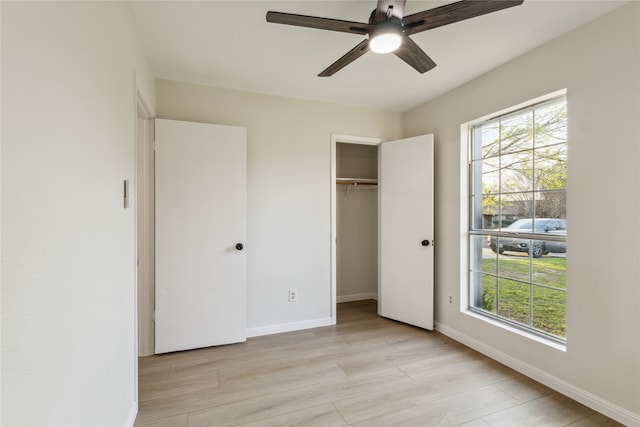 unfurnished bedroom featuring light wood-type flooring, baseboards, a closet, and ceiling fan