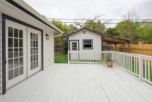 wooden terrace with an outdoor structure and a fenced backyard
