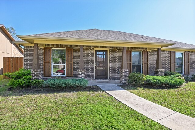 ranch-style house featuring brick siding and a shingled roof