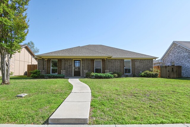 ranch-style home featuring brick siding and roof with shingles