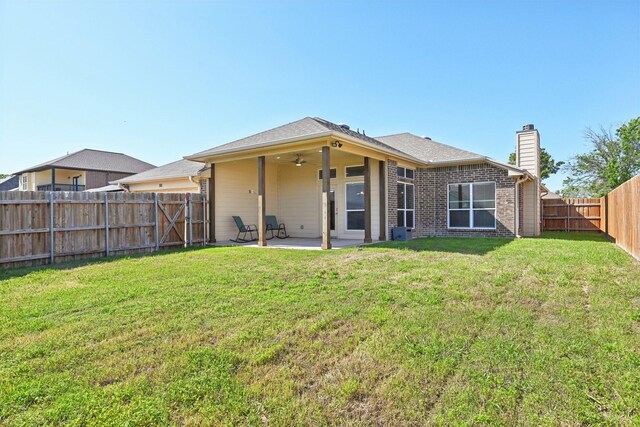 back of property with a patio area, ceiling fan, and a chimney