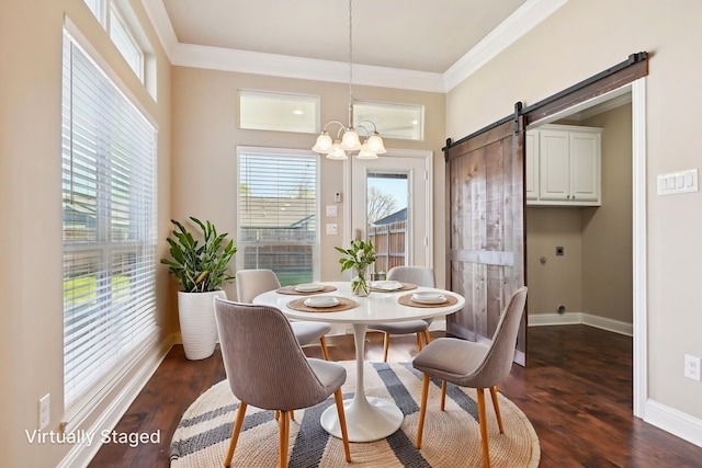 dining space with a barn door, ornamental molding, dark wood-style floors, a chandelier, and healthy amount of natural light