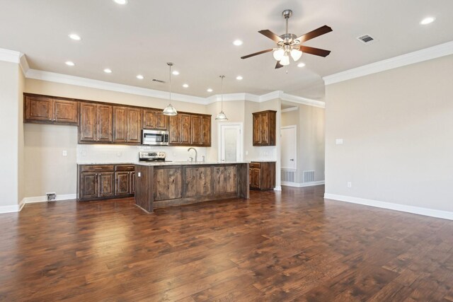 kitchen with appliances with stainless steel finishes, a ceiling fan, a sink, a kitchen island with sink, and light countertops