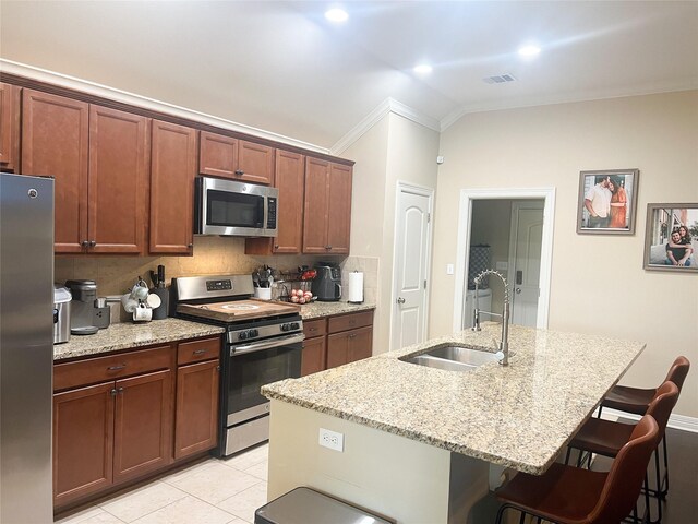 9812 Shadybrooke Dr, Shreveport, LA 71115 - kitchen with stainless steel appliances, a sink, ornamental molding, a kitchen bar, and light stone countertops