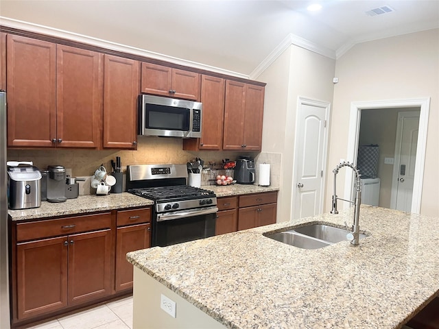 9812 Shadybrooke Dr, Shreveport, LA 71115 - kitchen featuring appliances with stainless steel finishes, a sink, crown molding, light stone counters, and a center island with sink