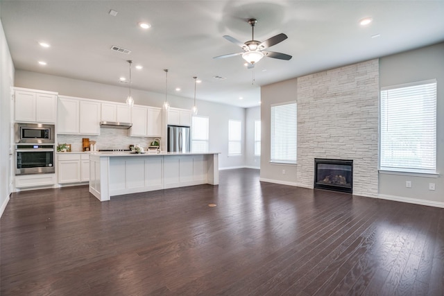 3001 Renmuir Dr, Prosper, TX 75078 - kitchen featuring appliances with stainless steel finishes, ceiling fan, light countertops, decorative backsplash, and open floor plan