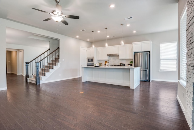 3001 Renmuir Dr, Prosper, TX 75078 - kitchen with appliances with stainless steel finishes, decorative backsplash, white cabinets, ceiling fan, and dark wood finished floors