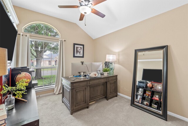 home office with ceiling fan, healthy amount of natural light, lofted ceiling, and light carpet