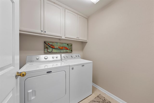 laundry room featuring cabinet space, washer and clothes dryer, baseboards, and light tile patterned floors