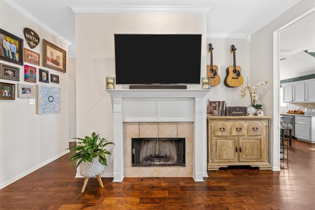 living area with dark wood-style flooring, ornamental molding, a fireplace, and baseboards