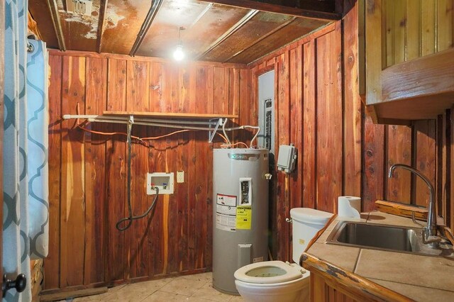 utility room with electric water heater and a sink