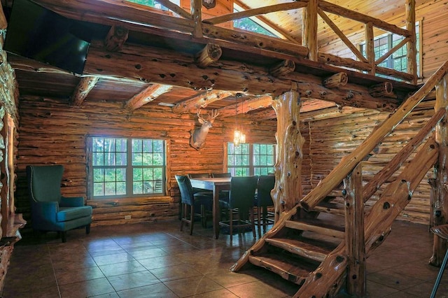 tiled dining room with log walls, beamed ceiling, wood ceiling, and a towering ceiling