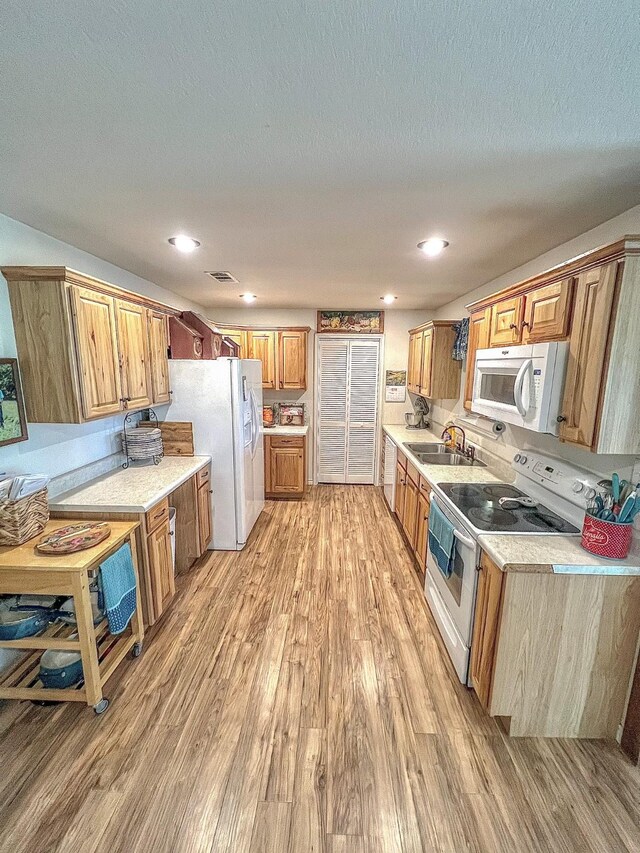 6861 County Road 4710, Larue, TX 75770 - kitchen with white appliances, a sink, light wood-style floors, light countertops, and a textured ceiling