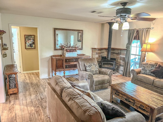 6861 County Road 4710, Larue, TX 75770 - living area with a wood stove, ceiling fan, light wood-style floors, and baseboards