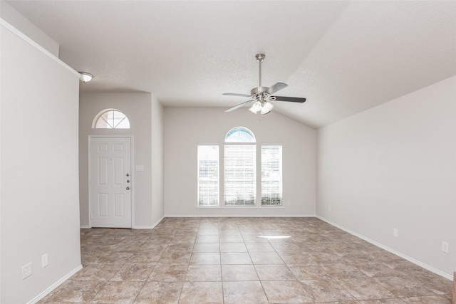 entryway with a ceiling fan, lofted ceiling, baseboards, and a textured ceiling