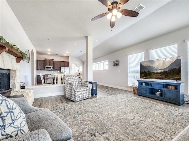1152 Snowy Owl Dr, Alvarado, TX 76009 - living area featuring vaulted ceiling, ceiling fan, a stone fireplace, baseboards, and light wood-style floors