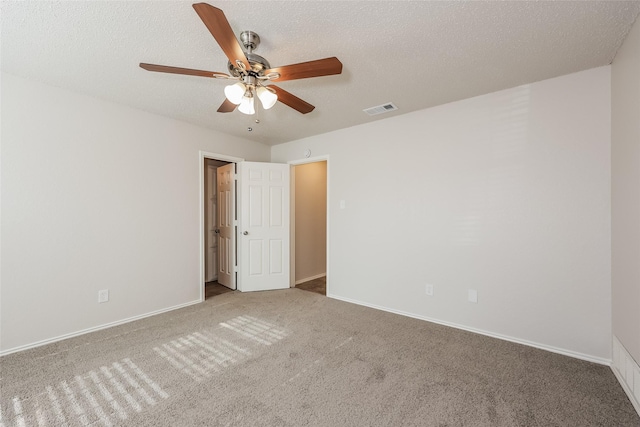 spare room featuring carpet floors, a ceiling fan, baseboards, and a textured ceiling