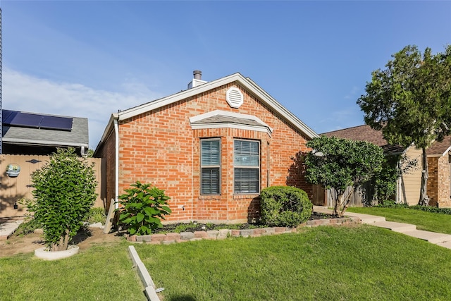 view of front facade featuring brick siding and a front lawn