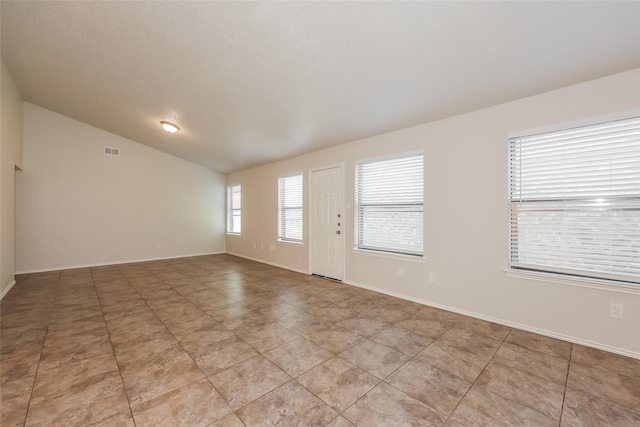 unfurnished living room featuring vaulted ceiling, baseboards, and light tile patterned flooring