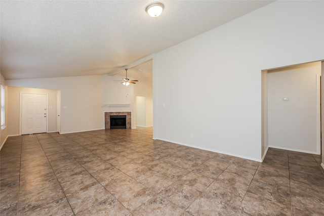 unfurnished living room featuring lofted ceiling, ceiling fan, a tiled fireplace, a textured ceiling, and baseboards