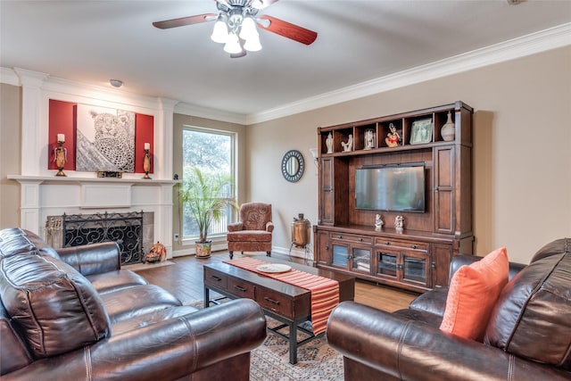 living area featuring crown molding, a ceiling fan, light wood-style flooring, and a fireplace with flush hearth