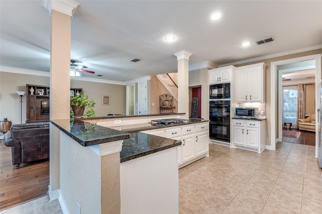 kitchen with decorative columns, ornamental molding, white cabinets, a ceiling fan, and dark stone countertops