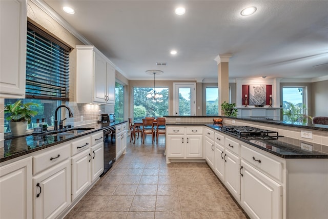 kitchen featuring gas stovetop, tasteful backsplash, a sink, ornamental molding, and white cabinets