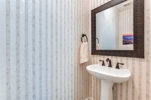 bathroom with wallpapered walls