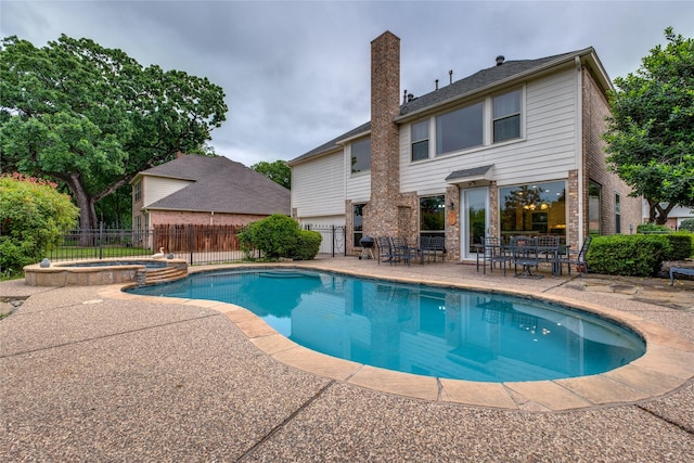 view of pool featuring a patio area, a pool with connected hot tub, and outdoor dining area