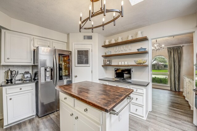 4020 Kerr Ct, Farmers Branch, TX 75244 - kitchen with a chandelier, stainless steel fridge with ice dispenser, wood counters, light wood-type flooring, and a textured ceiling