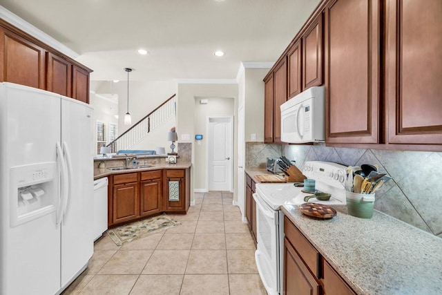 kitchen with white appliances, a sink, decorative backsplash, light stone countertops, and pendant lighting