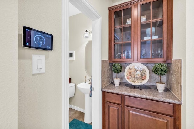 bar area with tasteful backsplash and baseboards