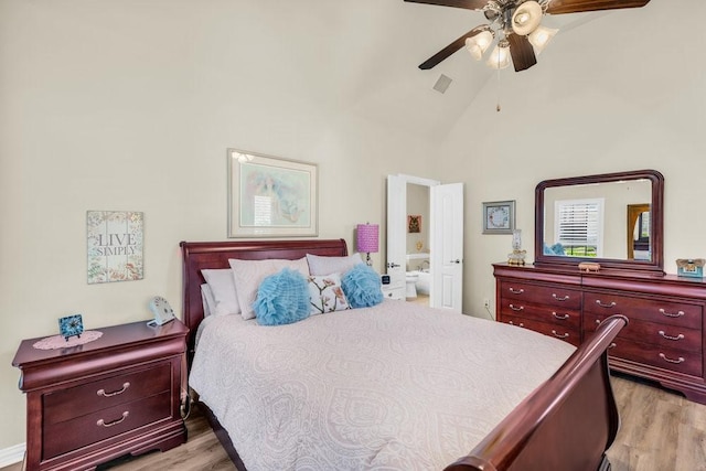 bedroom with light wood-type flooring, ensuite bath, high vaulted ceiling, and ceiling fan